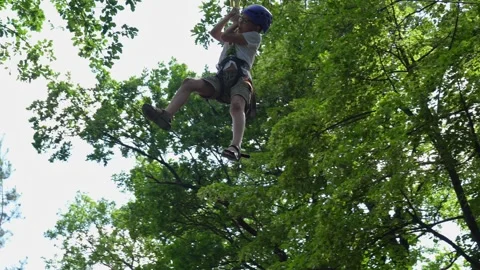 Boy in rope park makes bungee jump and flies on carabiner. Stock Footage 280488105