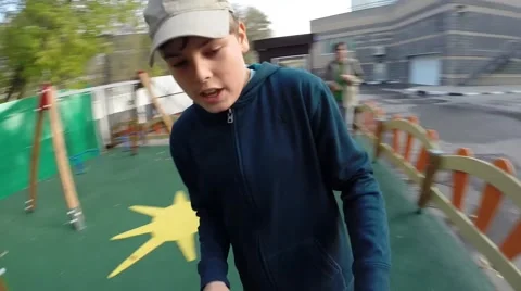 Boy rotating on children playground, hands of girl rotating with him Stock Footage 64213167