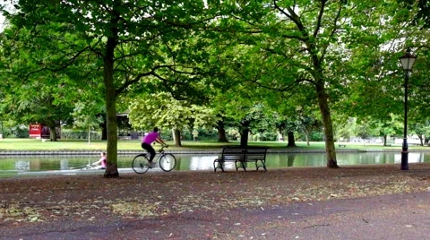 Boy rowing boat on river with trainer riding bicycle Video stock 45842245