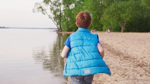 Boy run on sandy beach along coastline at summer day Stock Footage 108660686
