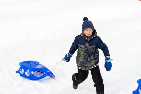 Boy runing with  A sledge, winter time Stock Photos
