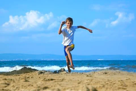 Boy running along beach Stock Photos
