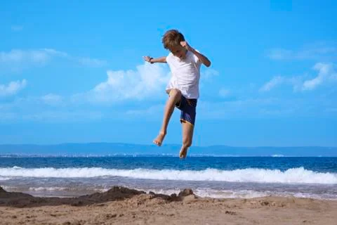 Boy running along beach Stock Photos