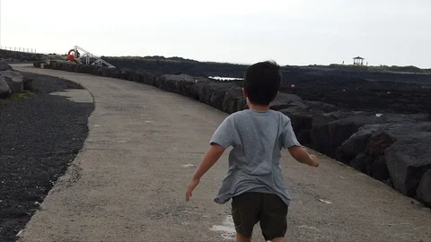 A boy running along the coastline. Stock Footage 117416203