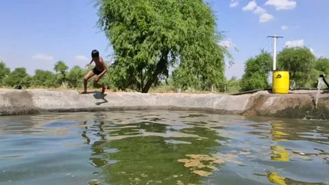 A boy running and jumping in the pool, slow motion footage Stock Footage 134216876
