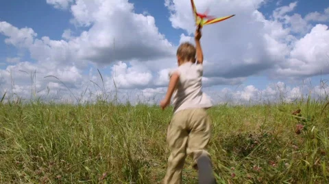 Boy running back and forth in the field with airplane Video stock 605624