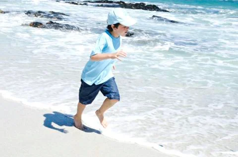 Boy running on the beach, outdoors Stock Photos