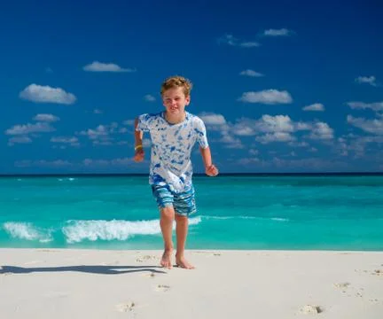 Boy running on beach Stock Photos