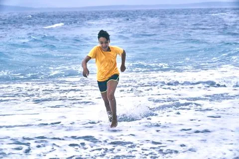 Boy running on the beach Stock Photos