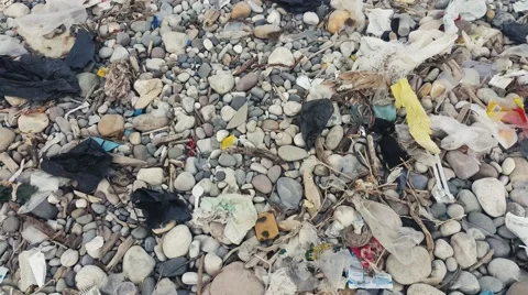 A boy running on Garbage plastic pollution in a beach in Caspian sea Stock Footage 58952114