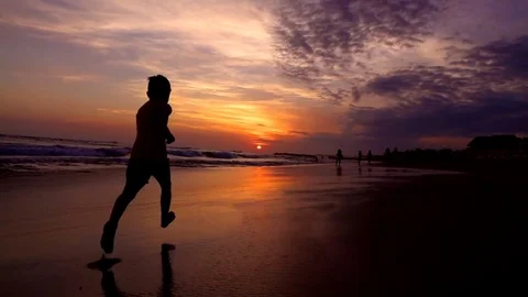 Boy running with his father on the beach at the evening, slow motion shot at 240 Stock Footage 80412158