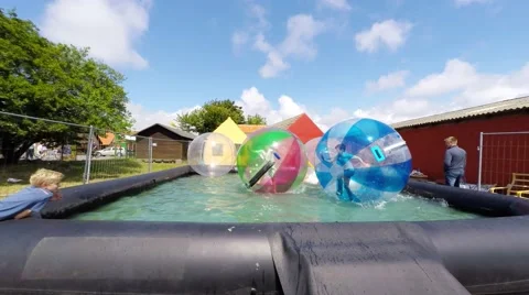 Boy running  inside a funball floating on the water surface Stock-Footage 52190217