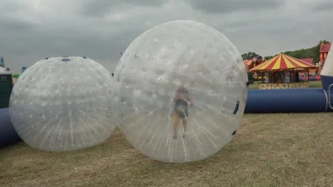 Boy  running inside the Zorbs Stock Footage 113456872