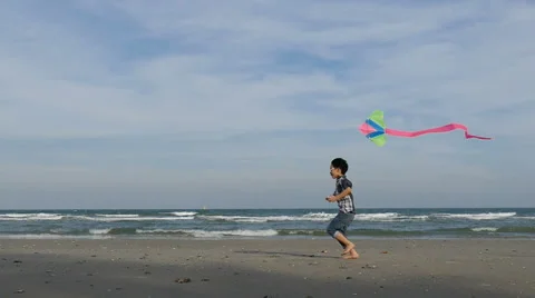 Boy running with kite at beach, slow motion. Stock Footage 60598180