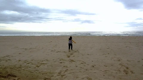 Boy running to the ocean on the beach Stock Footage 86696522