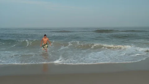 Boy running into Ocean water Stock Footage 95690616