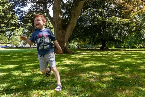 Boy running in a park Stock Photos