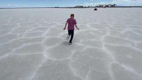 Boy running past camera at famous Bonneville Salt Flats Stock Footage 131331053