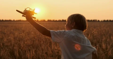 Boy is running with a plane in his hands. Boy is playing with a wooden airpla Stock Footage 119527294