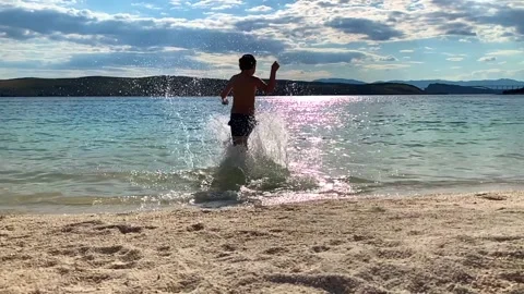 Boy running into the sea Stock Footage 133368990