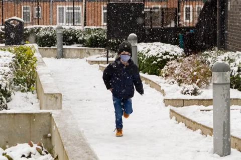A boy running in the snow Stock Photos