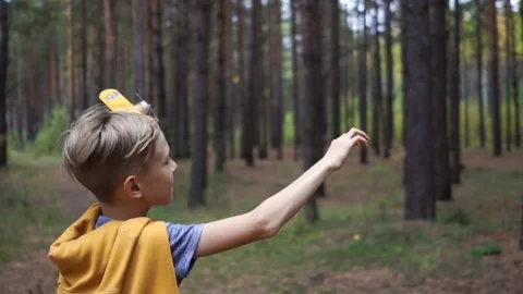 A boy running through the forest with a small plane Stock Footage 147250114