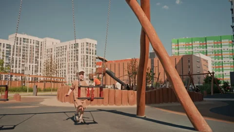 Boy Running Towards Swing In Urban Playground With Apartment Buildings Vídeos de archivo 345967666