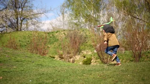 The boy is running with a toy airplane Stock Footage 75176772