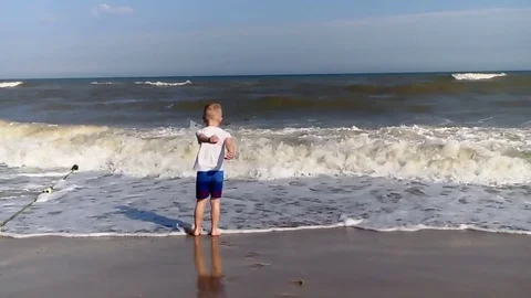 The boy runs around the sea Stock Footage 80446699