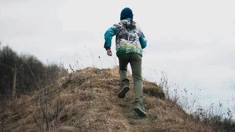 The boy runs up the hill on the path. Very cheerful. Cool slow-motion shots Stock Footage 128016363