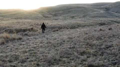 The boy runs to sunset on a hill Stock Footage 105027975