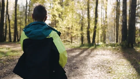 A boy runs through the autumn forest in good weather Stock Footage 162826452