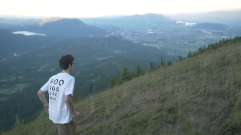 Boy runs through field with mountain views Video stock 154326244