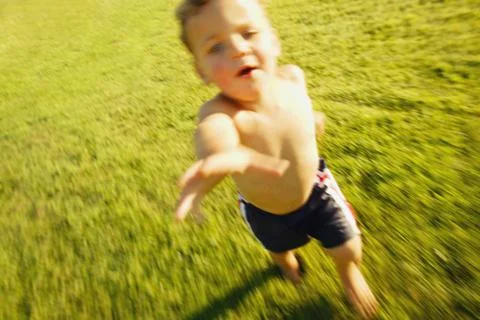 Boy Runs Through Grass Stock Photos