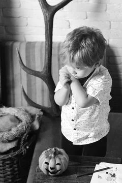 Boy on rustic and white brick wall background. Kid with cute and dreamy face Stock Photos