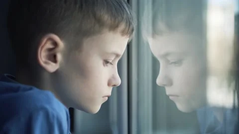 The boy is sad looking out the window Stock Footage