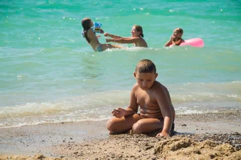 Boy on the sand on the beach Stock Photos