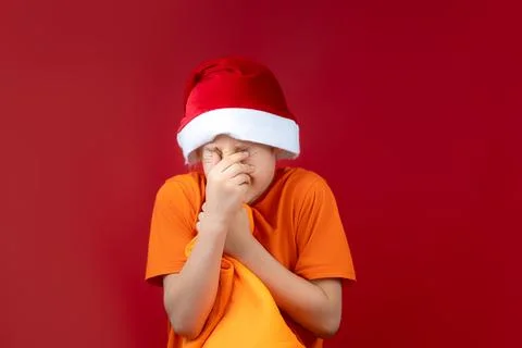 A boy in a Santa hat on a red background Stock-Fotos