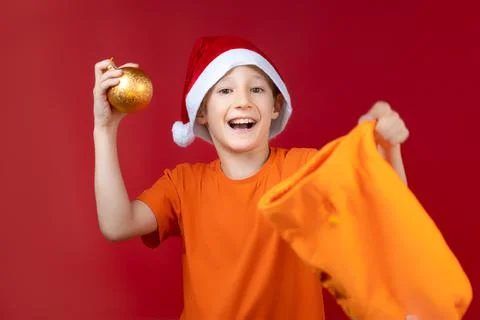 A boy in a Santa hat on a red background Stock-Fotos