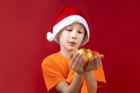 A boy in a Santa hat on a red background Stock Photos