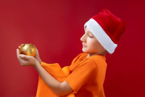 A boy in a Santa hat on a red background Stock Photos