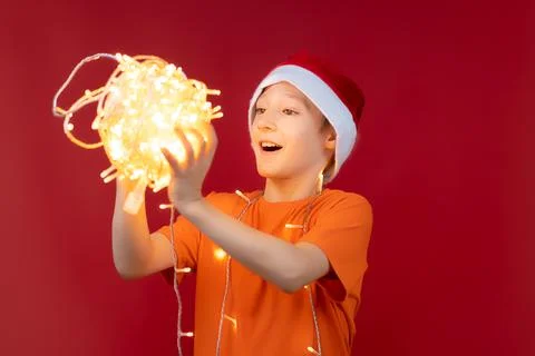 A boy in a Santa hat on a red background Stock-Fotos