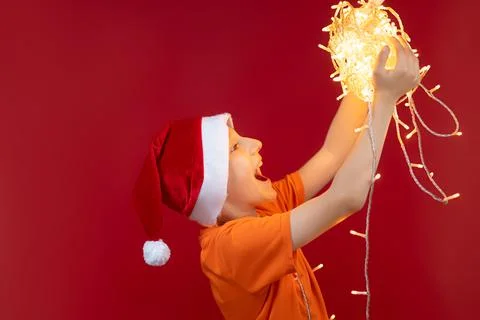 A boy in a Santa hat on a red background Stock Photos