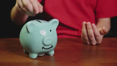 Boy saving money concept. kid put money in a piggy bank. child blond put coins Stock-Footage 146739284