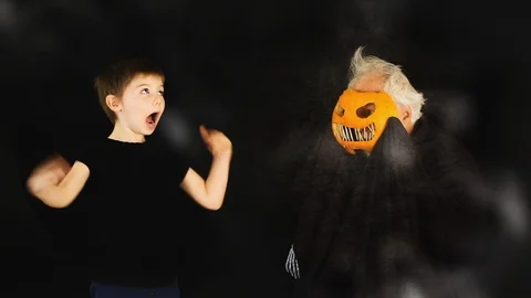 Boy Scared Of Grey Haired Pumpkin Head Stock Footage