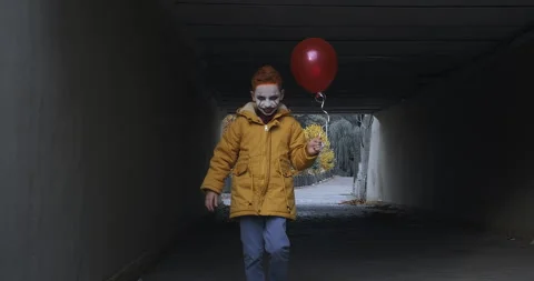 The boy in scary clown make-up with balloon Stock Footage 249071457