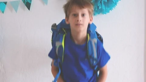 A boy with a school backpack on his back rejoices at the first day of school Stock Footage 205593068