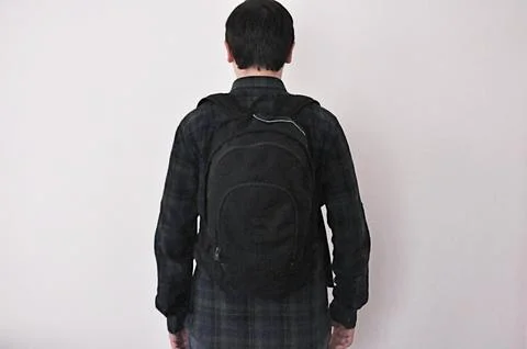 The boy with school backpack. Shot from behind. Stock Photos