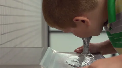 Boy at school getting drink of water Vídeos de archivo 26583376