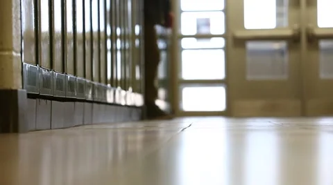 Boy in school walks towards camera along lockers Stock Footage 62943309